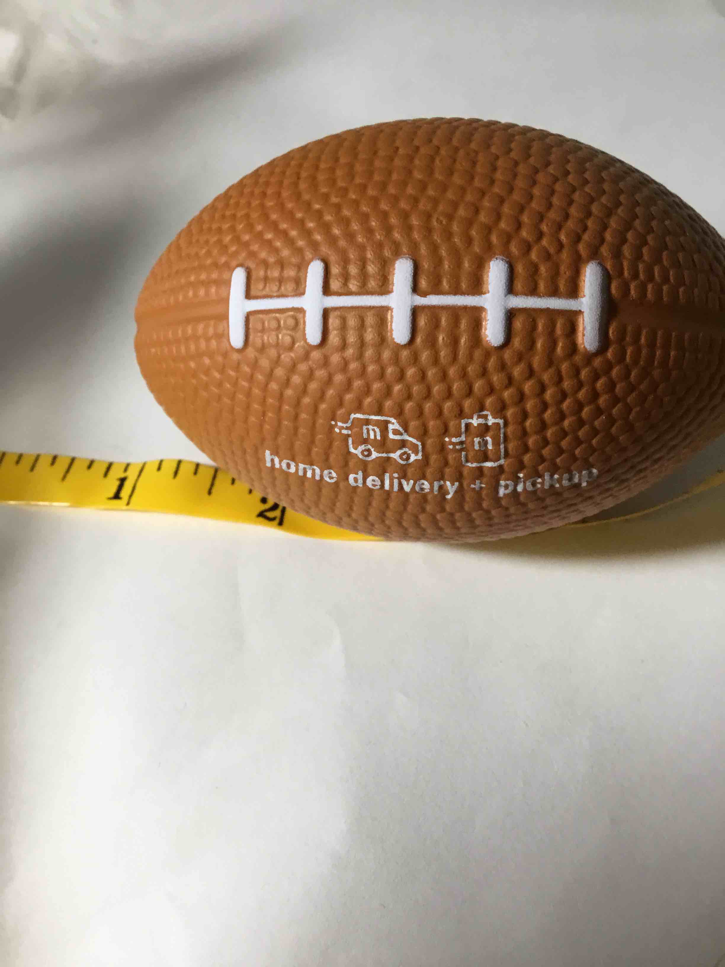 Meier promotional football shaped stress ball with "home delivery + pickup" text