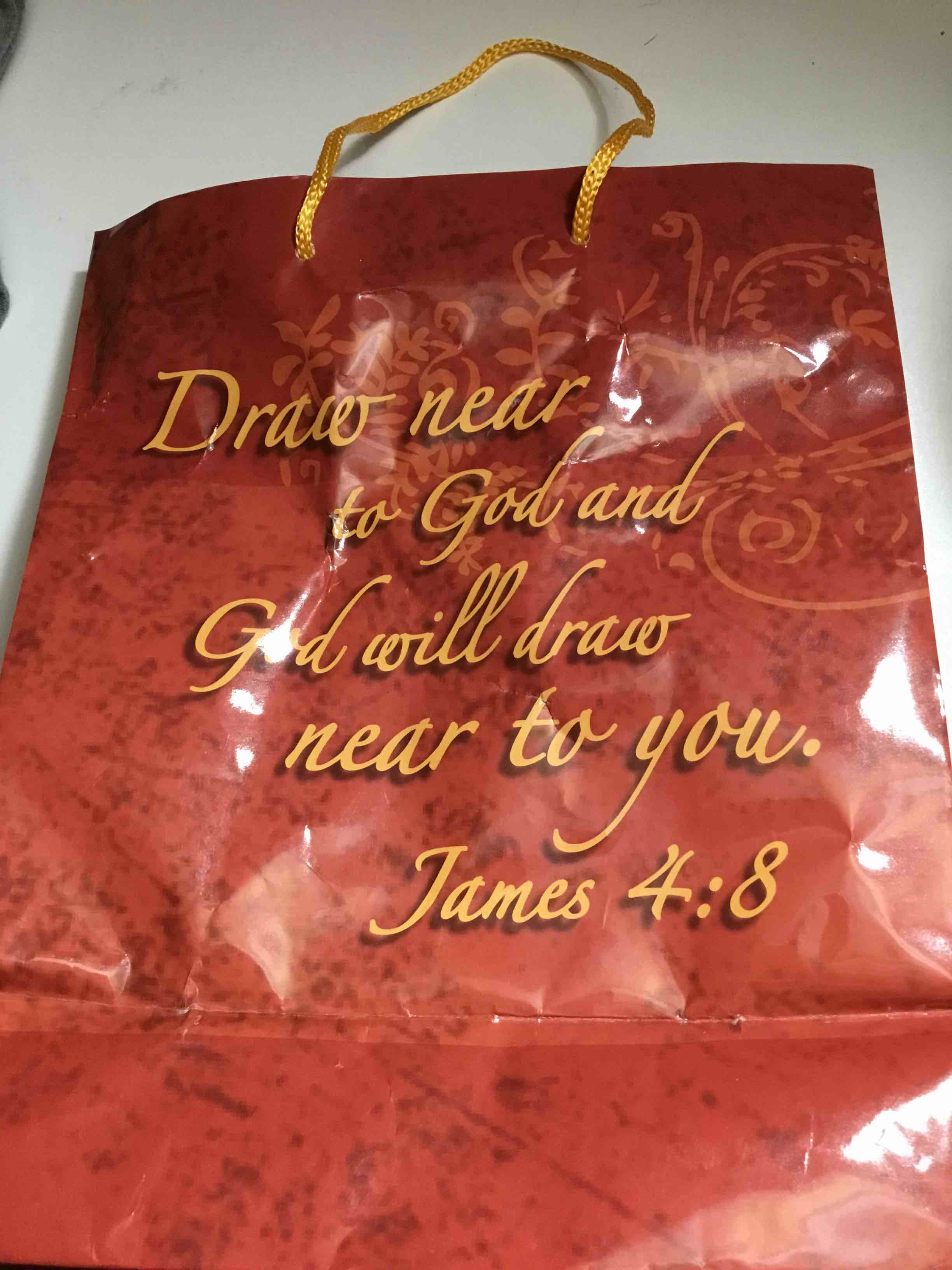 Red gift bag with a Bible verse printed on it
