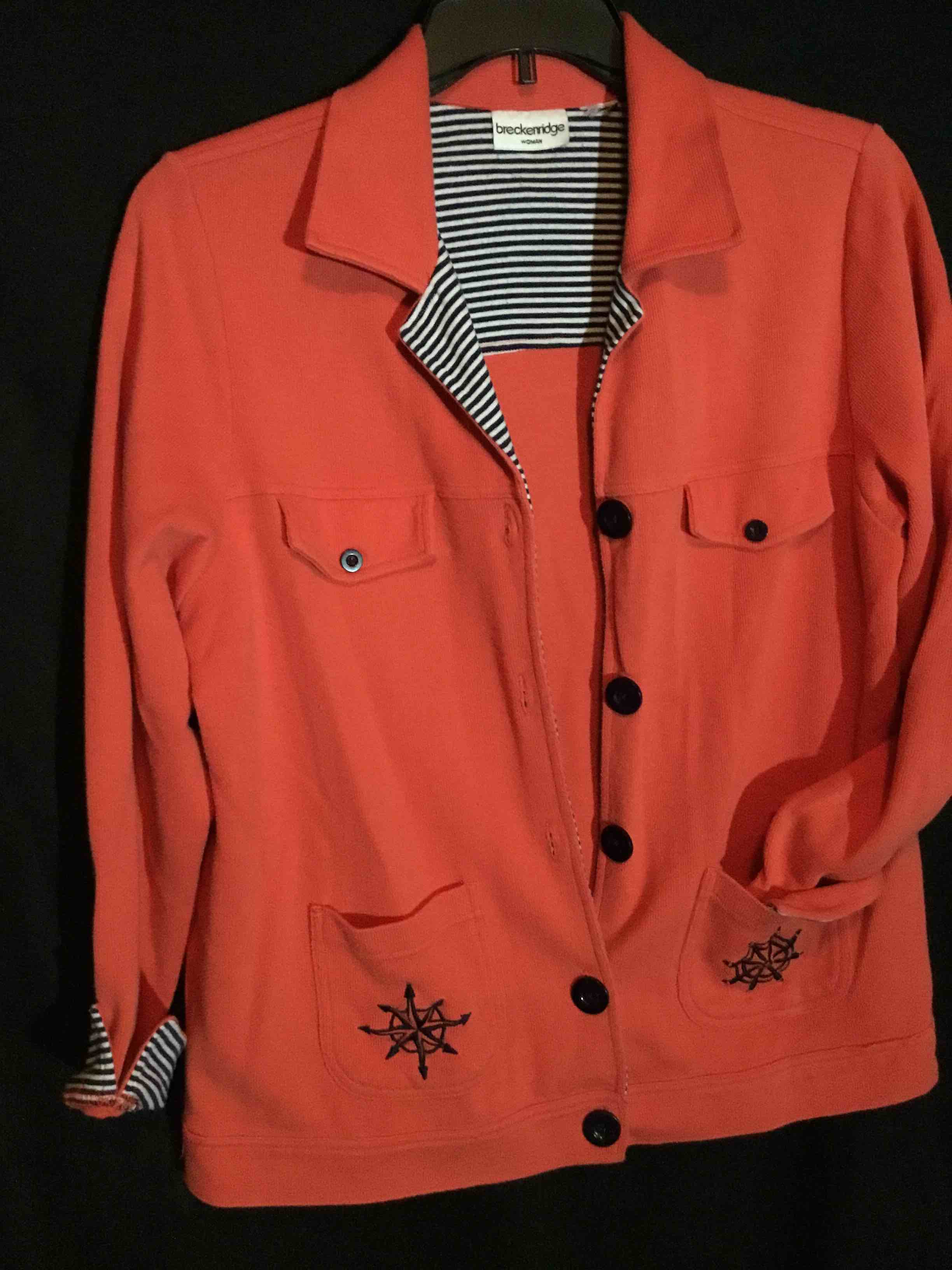 Breckenridge women's jacket in a coral/pink color with a navy and white striped lining