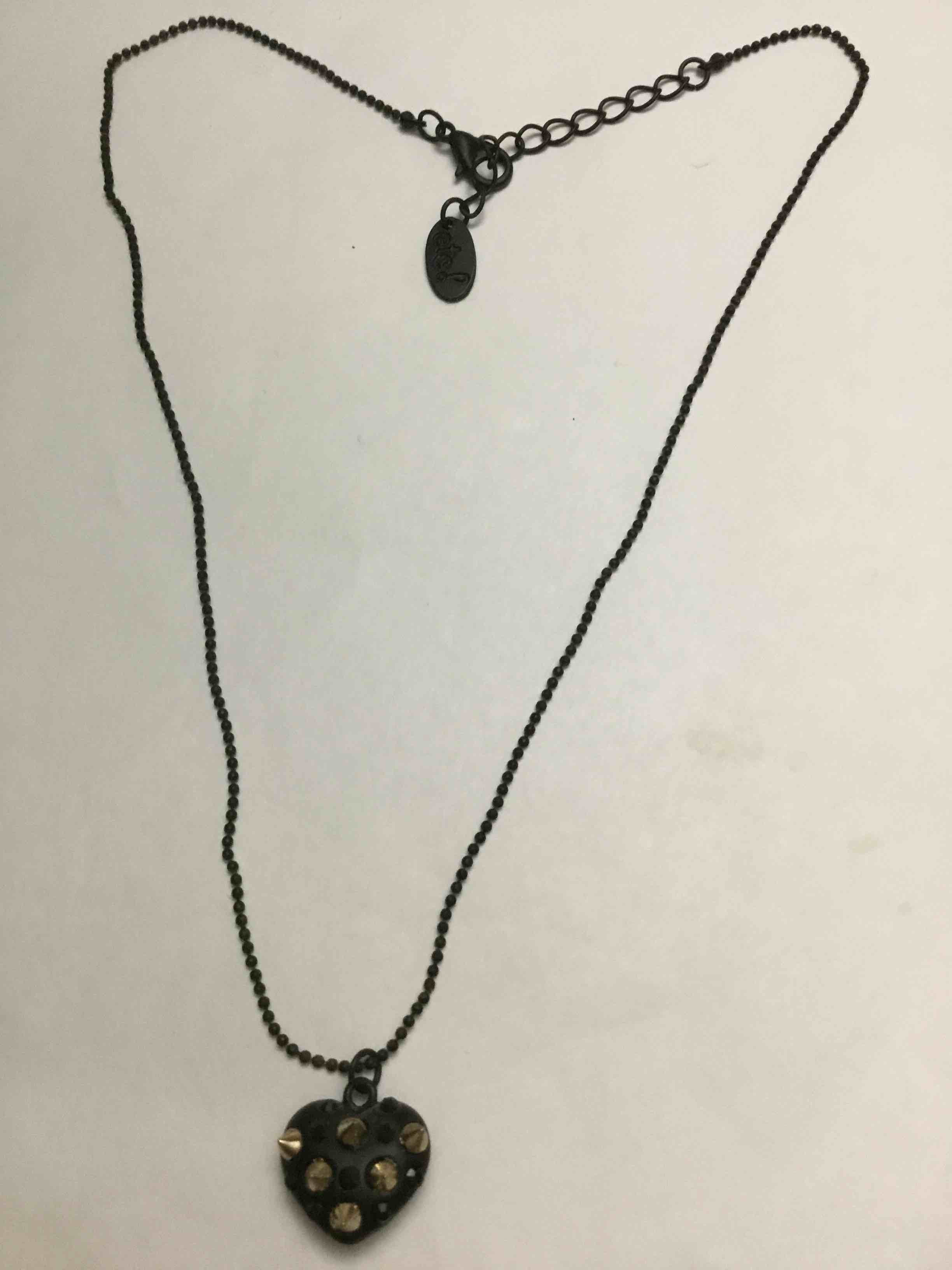 Black puffy heart pendant necklace with gold-toned studs and a black ball chain