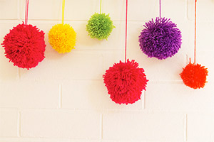 Make a variety of pom poms in different colours and sizes to create a decorative feature.