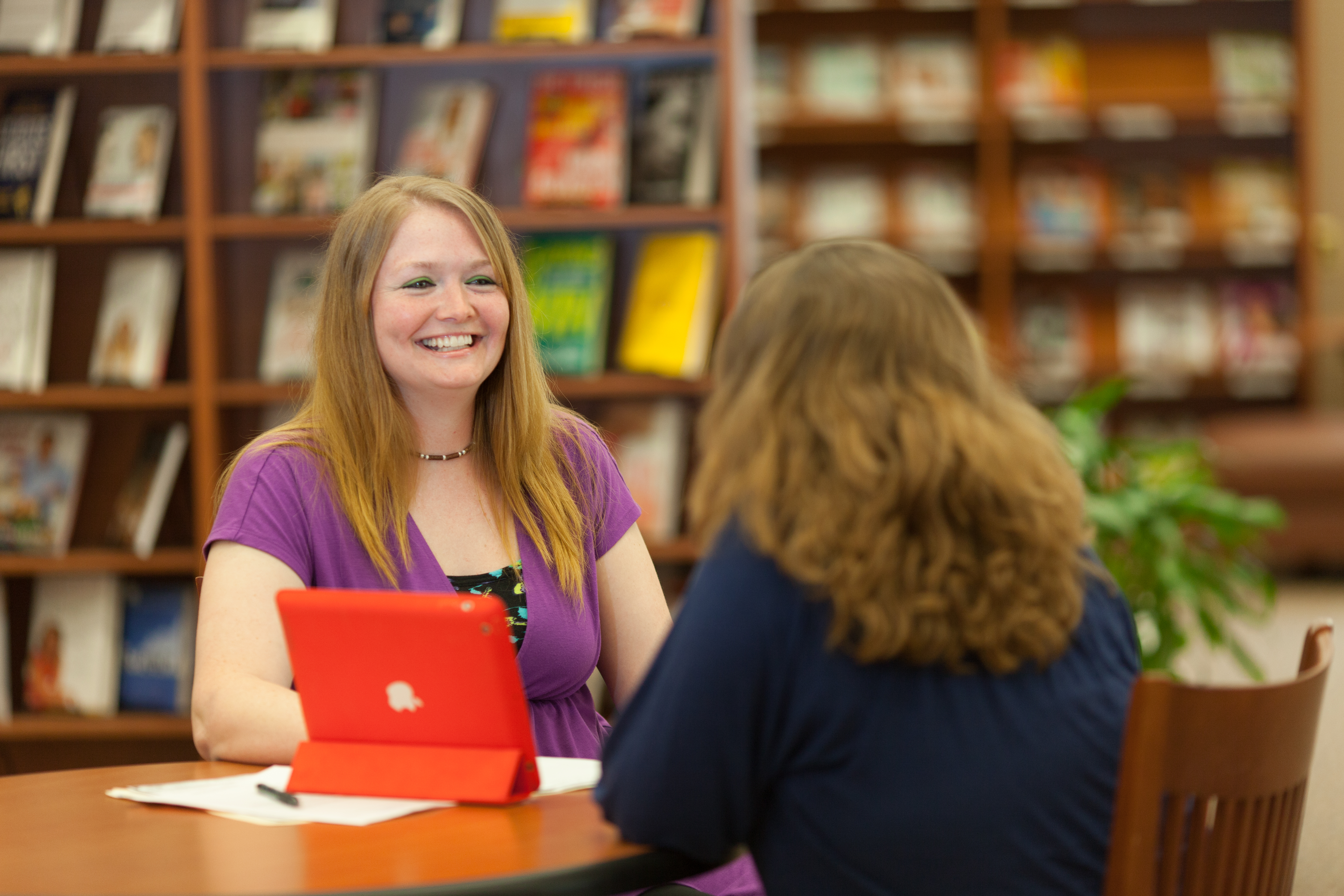 Two women talking together at a table