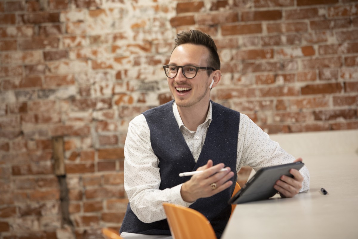 Man smiling holding a tablet