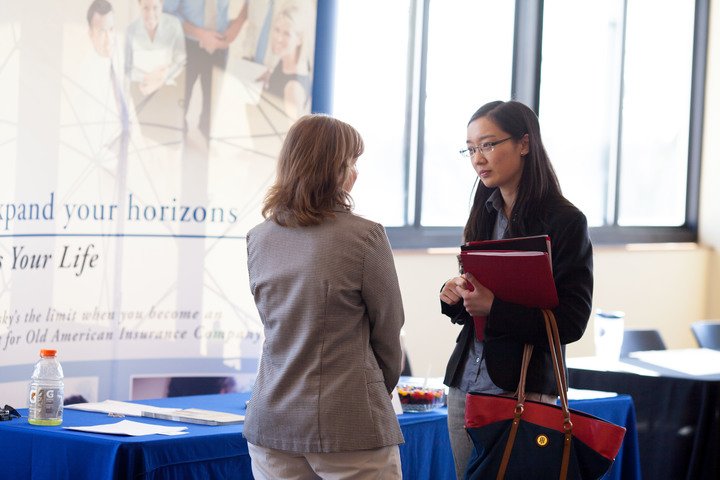 Two professionally dressed women talking together
