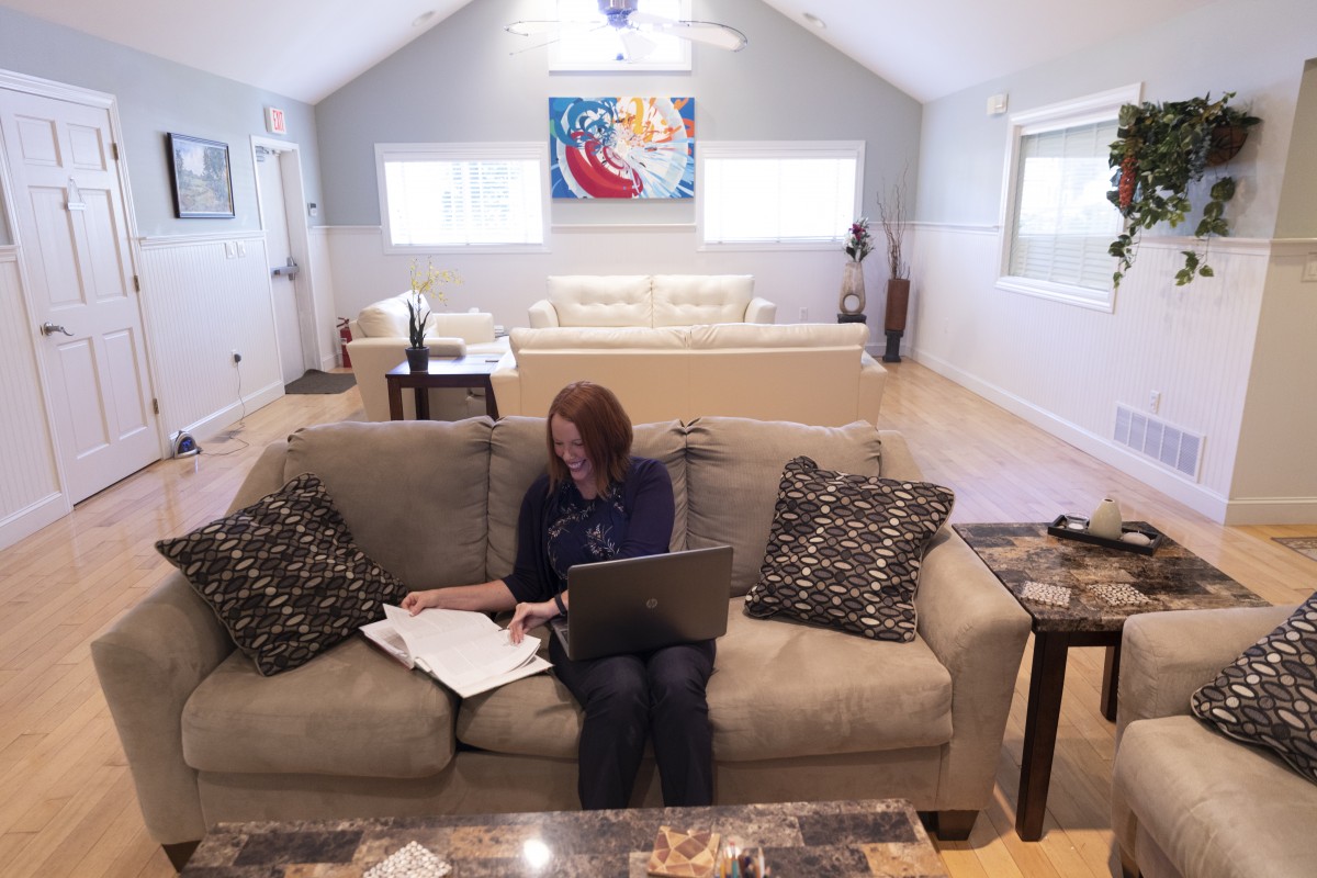 Image of a woman working on a couch.