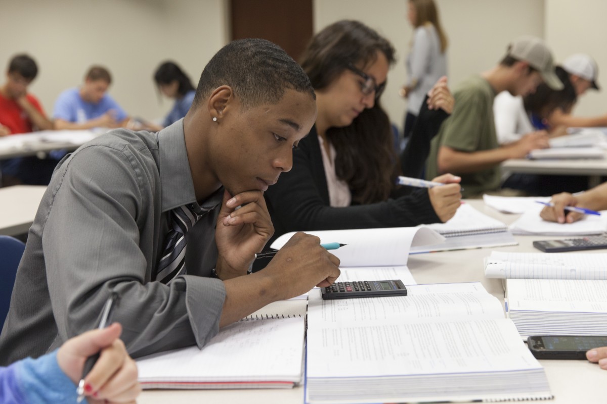 student using a calculator in a classroom