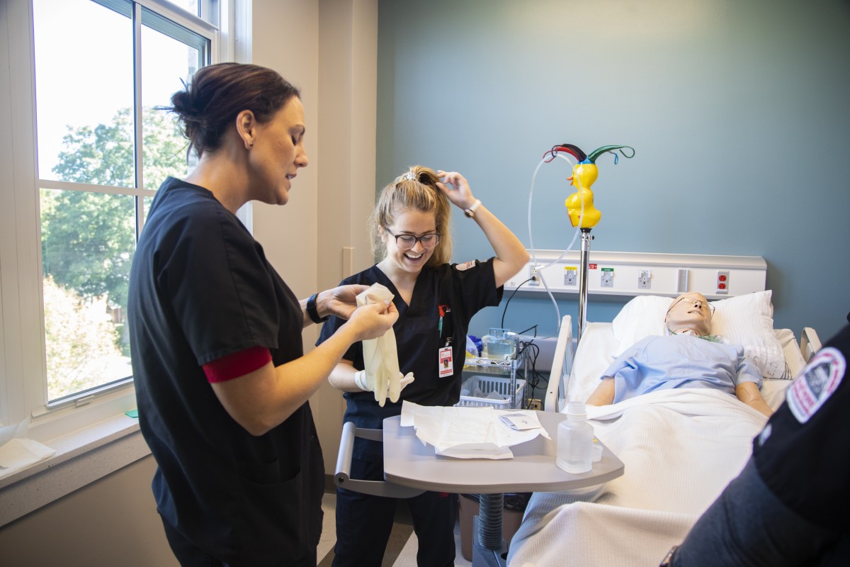 Nursing students working with a patient mannequin 