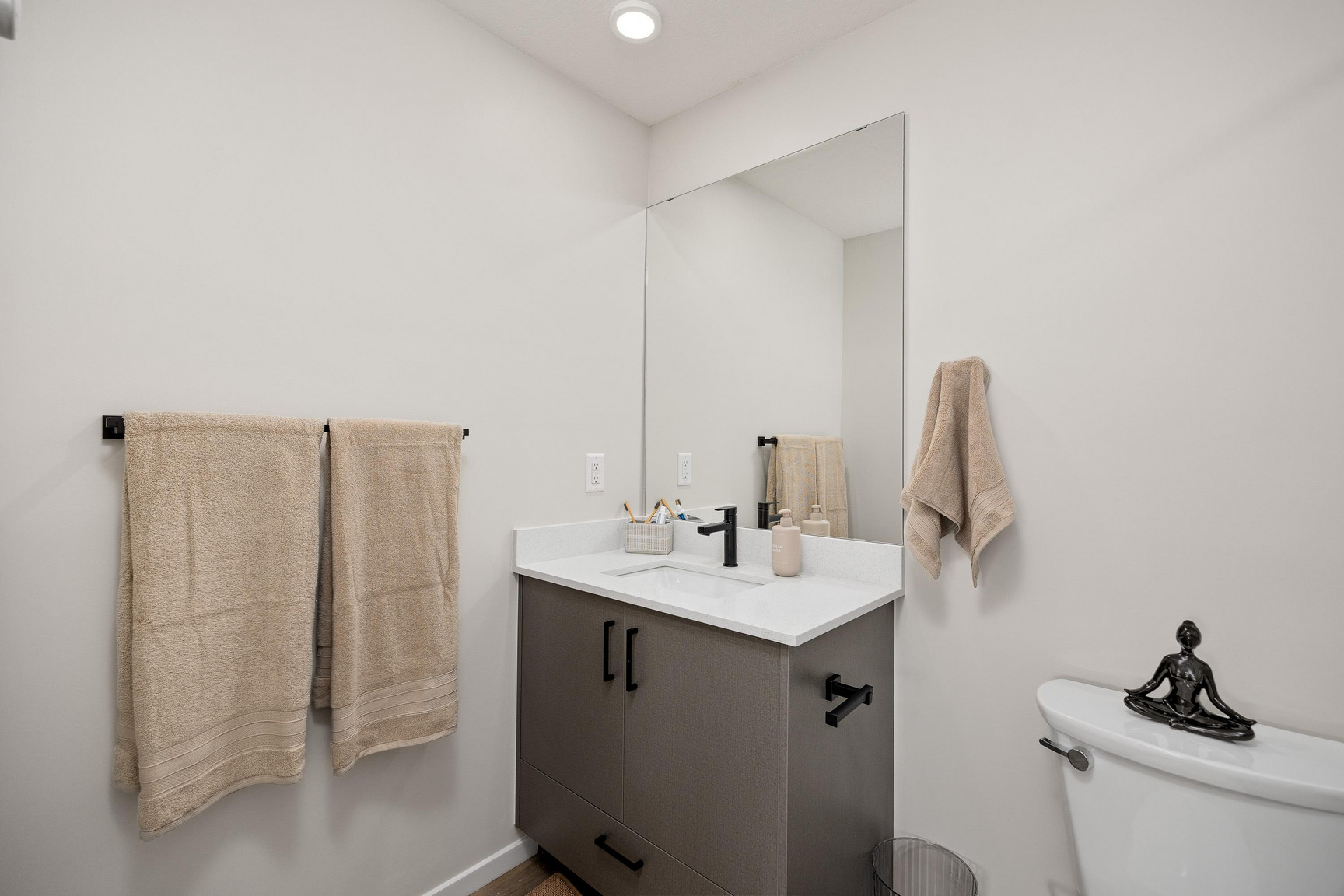 Cozy secondary bedroom at Central Kelowna with simple artwork and natural light in a fresh, modern two-bedroom apartment.