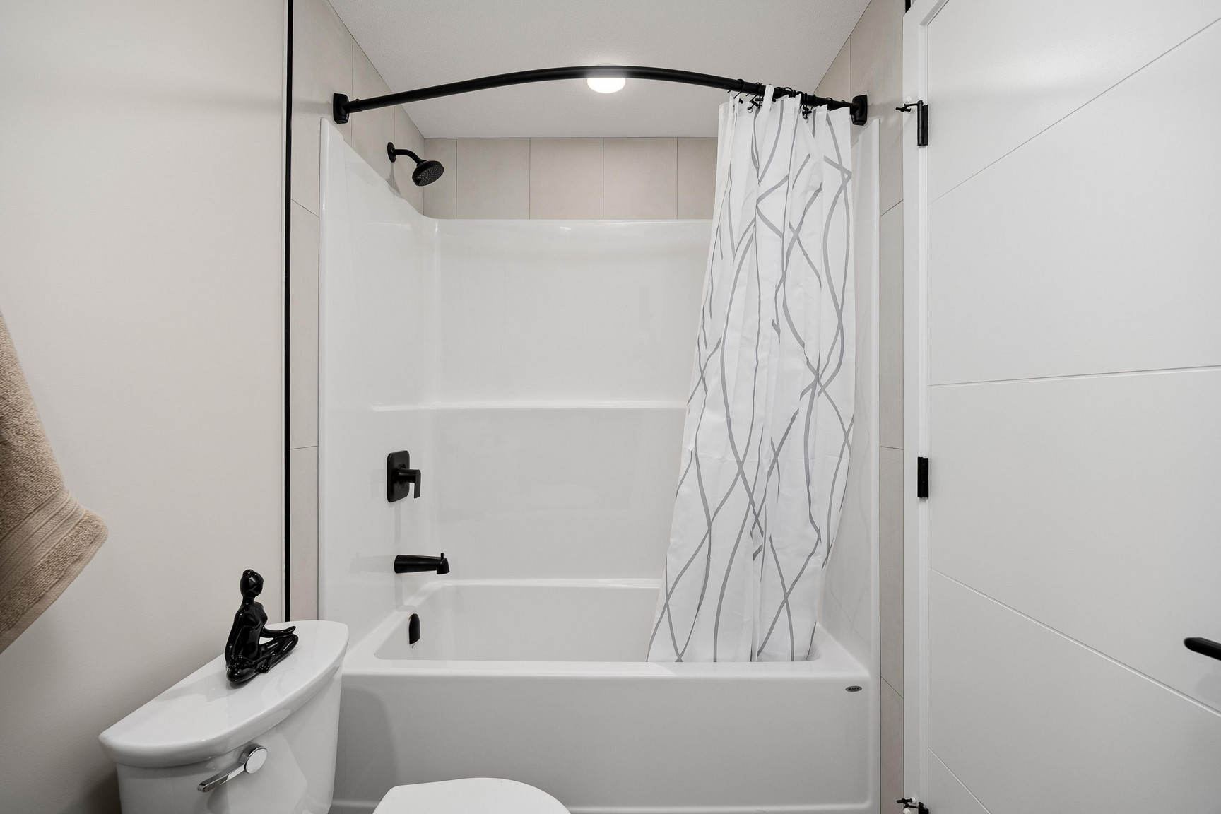 Modern bathroom at Central Kelowna with quartz vanity, sleek fixtures, and light tile finishes in a contemporary two-bedroom apartment.