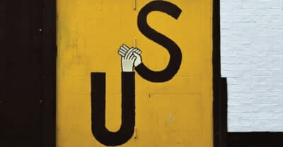 The word "Us" spelled out using arms