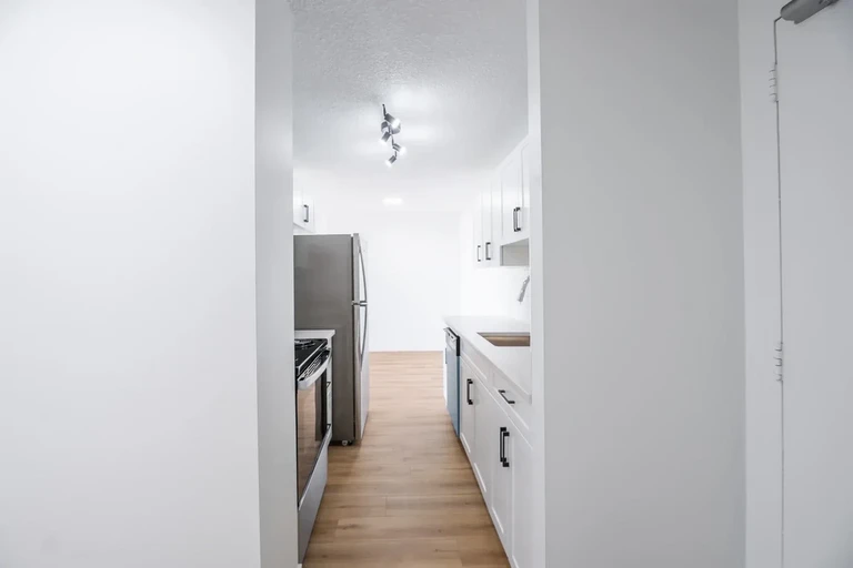 Galley style kitchen with appliances at Glenmore Heights in Calgary.