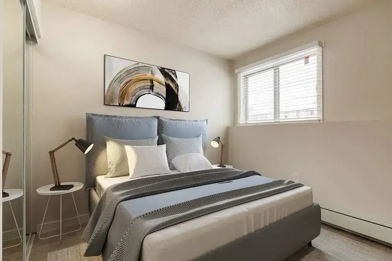 Good size bedroom with mirrored closet doors at Cotton Wood Apartments in Medicine Hat.