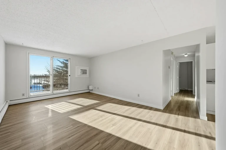 Bright living room with large windows at Northgate Manor II in Regina.