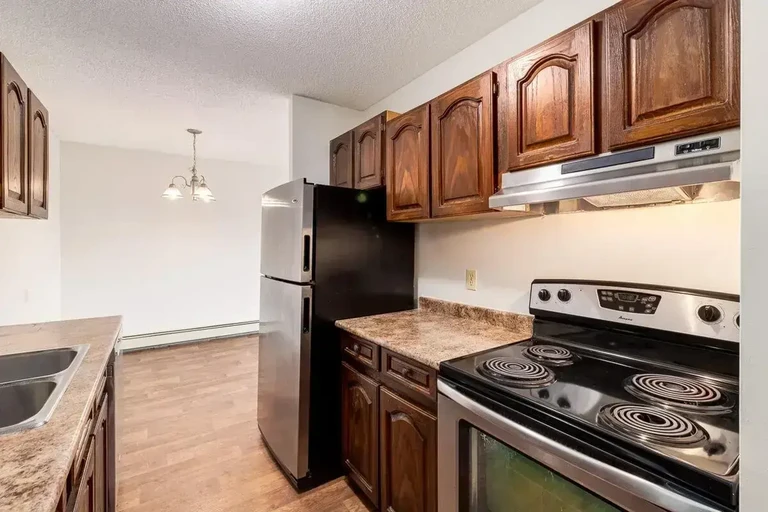 Updated kitchen featuring stainless steel fridge and stove at Applewood Village in Calgary.