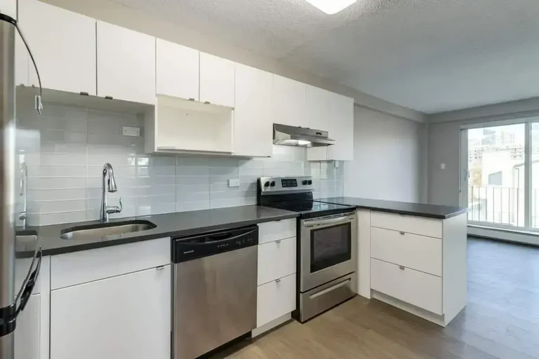 Stylish kitchen with stainless steel fridge, stove and dishwasher at Cameron County in Edmonton.