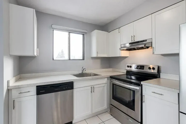 Contemporary kitchen with stainless steel appliances at Glenmore Gardens Towers in Calgary.