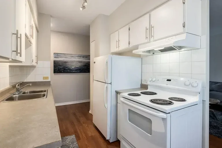 Galley style kitchen with appliances at Glenmore Heights in Calgary.