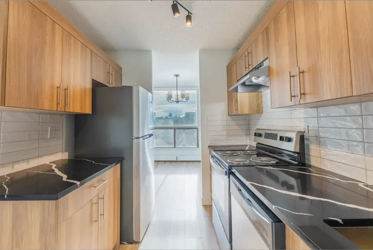 Bright modern kitchen with stainless steel appliances at Belmont House in Calgary. 
