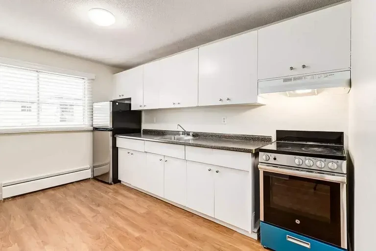 Stylish kitchen with stainless steel fridge and stove at Emerald Vista in Edmonton.