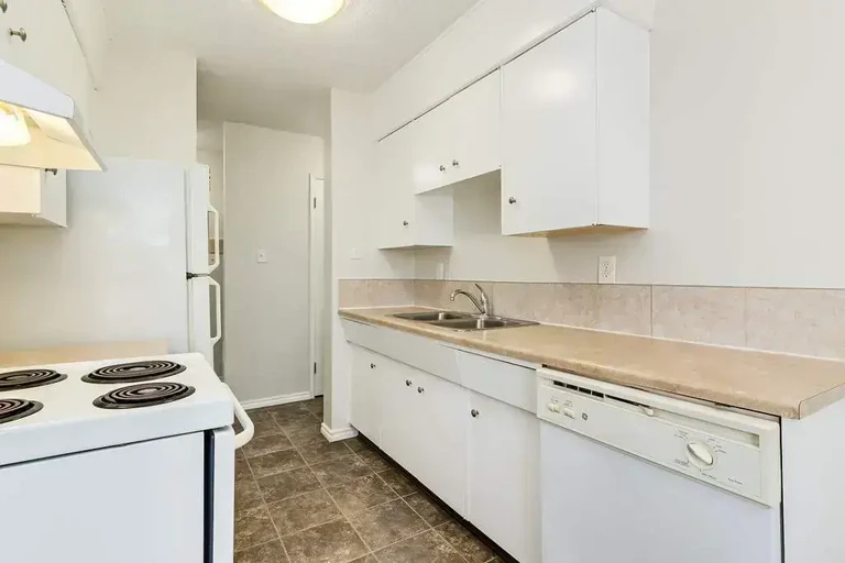 Galley style kitchen with appliances at Nine and Five Apartments in Edmonton.