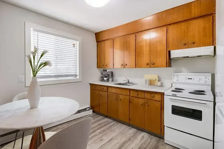 Compact kitchen with cabinets, countertop, sink, and space-saving layout at Allen Apartments.