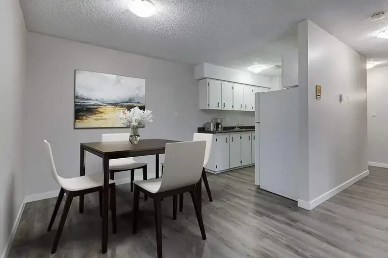 Dining area with access to galley style kitchen at Caswell Manor in Saskatoon.