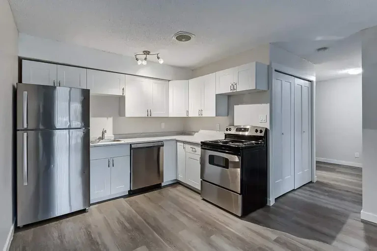 Stylish kitchen with stainless steel fridge and stove at Caswell Manor in Saskatoon.