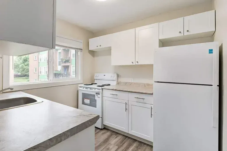 Galley style kitchen with appliances at Main Street Villa in Saskatoon.