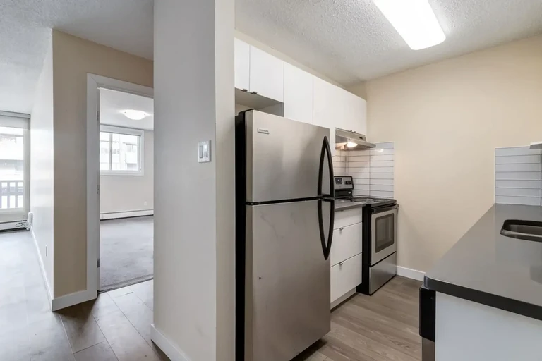 Modern kitchen with stainless steel appliances at Chinook Gardens in Calgary.