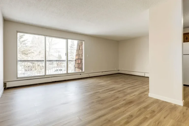 Bright living room with large windows at Grand Park Village in Camrose.