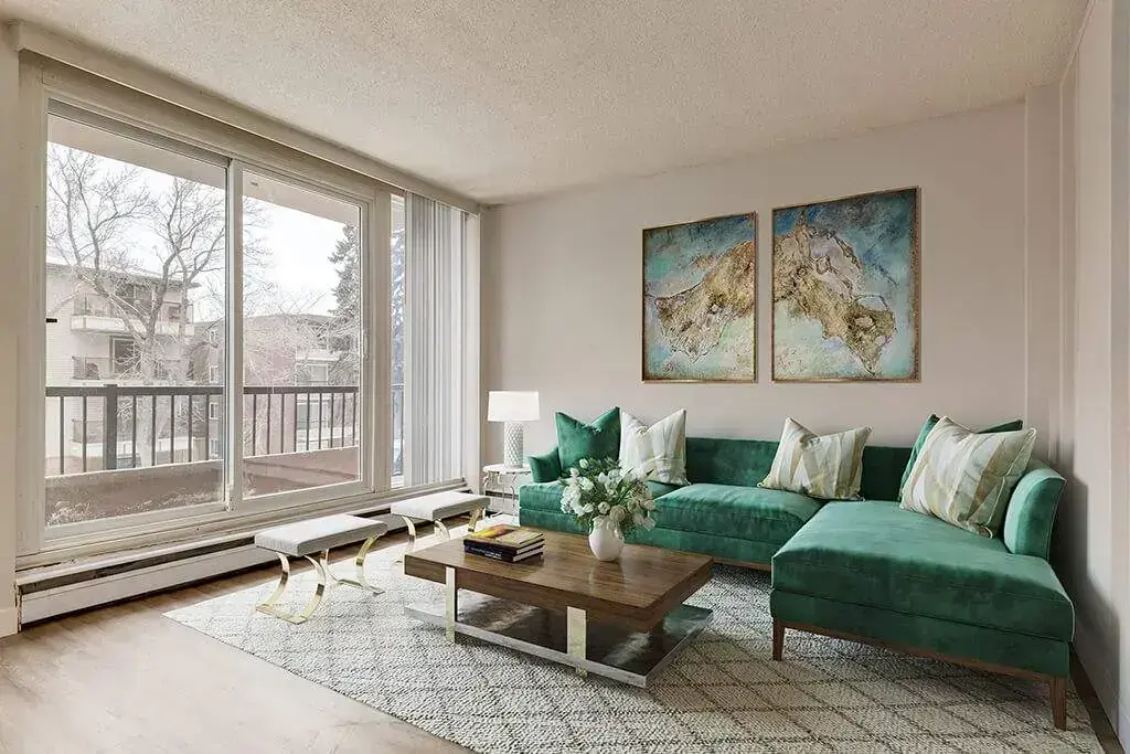 Sunlit living room with large windows at Alumni Apartments in Calgary.