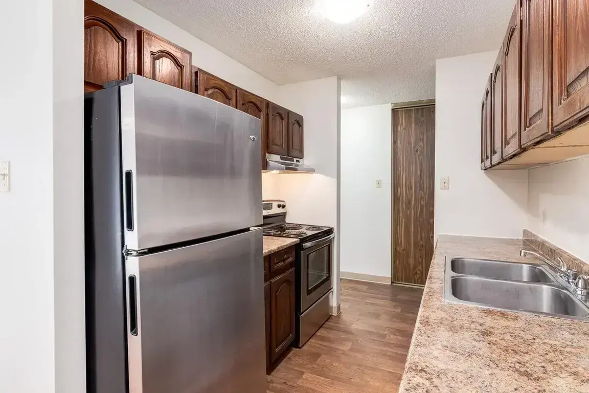 Stylish kitchen with stainless steel fridge and stove at Applewood Village in Calgary.