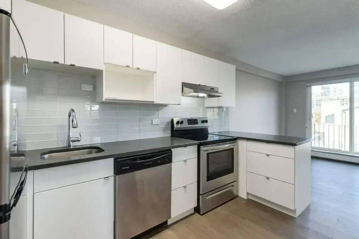 Stylish kitchen with stainless steel fridge, stove and dishwasher at Cameron County in Edmonton.