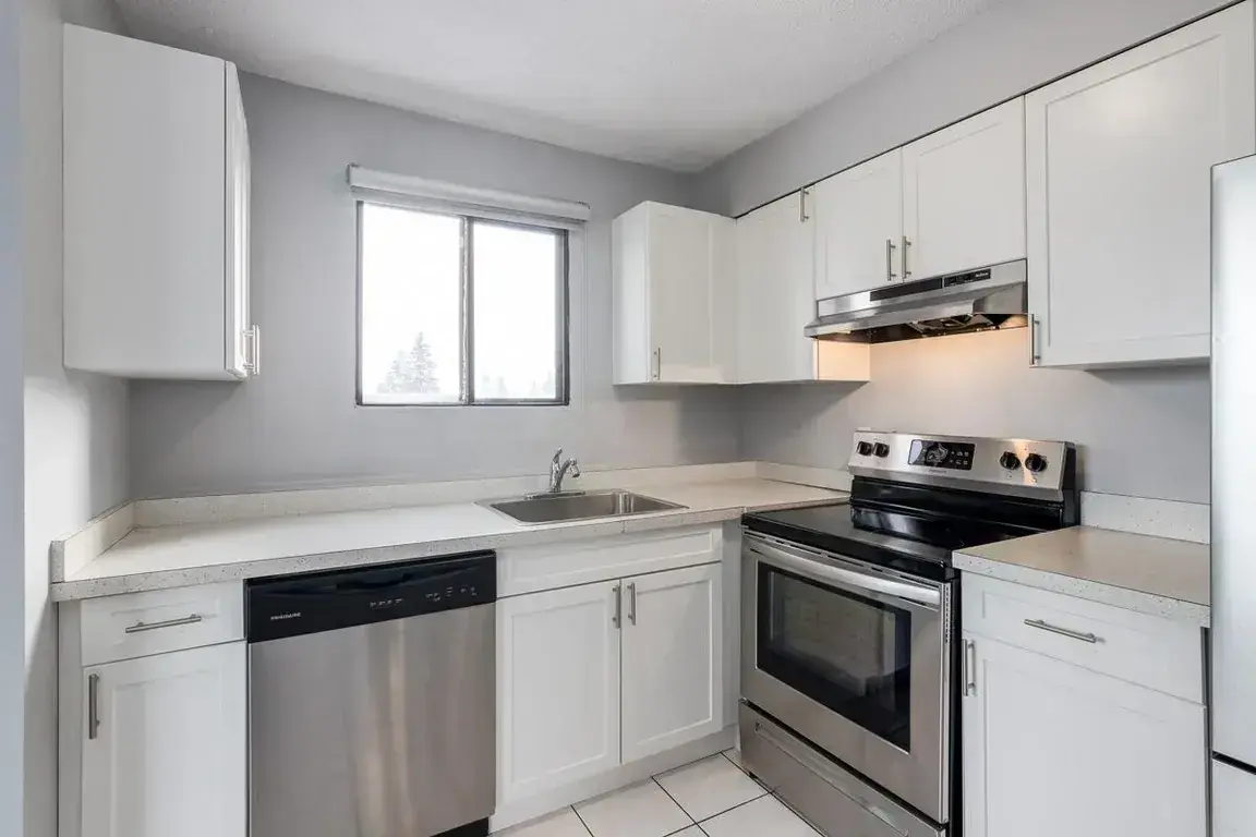 Contemporary kitchen with stainless steel appliances at Glenmore Gardens Towers in Calgary.