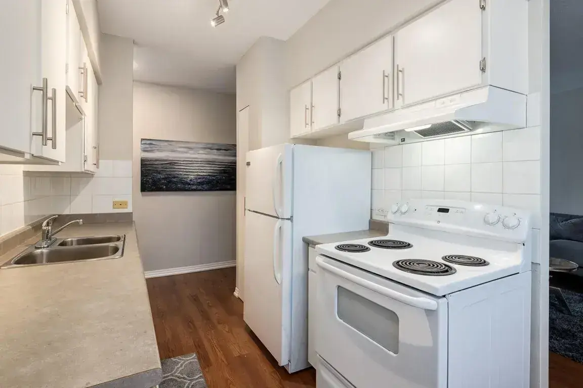 Galley style kitchen with appliances at Glenmore Heights in Calgary.
