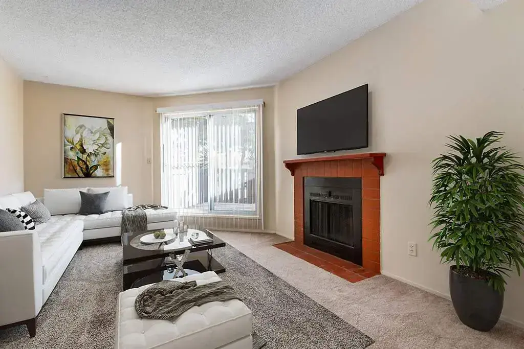 Sunlit living room with large windows at Sunridge Village in Calgary.