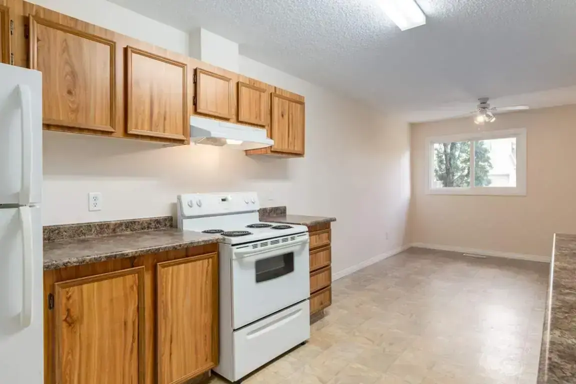 Galley style kitchen with appliances at Hooke County Townhomes in Edmonton.