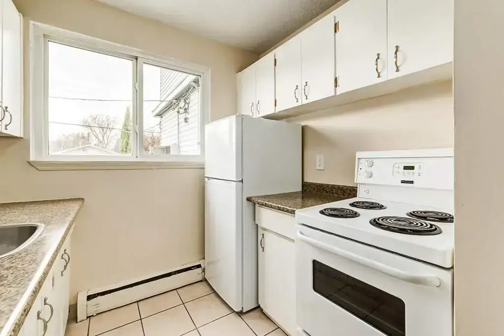 Galley style kitchen with natural light and appliances at Normandy in Edmonton.