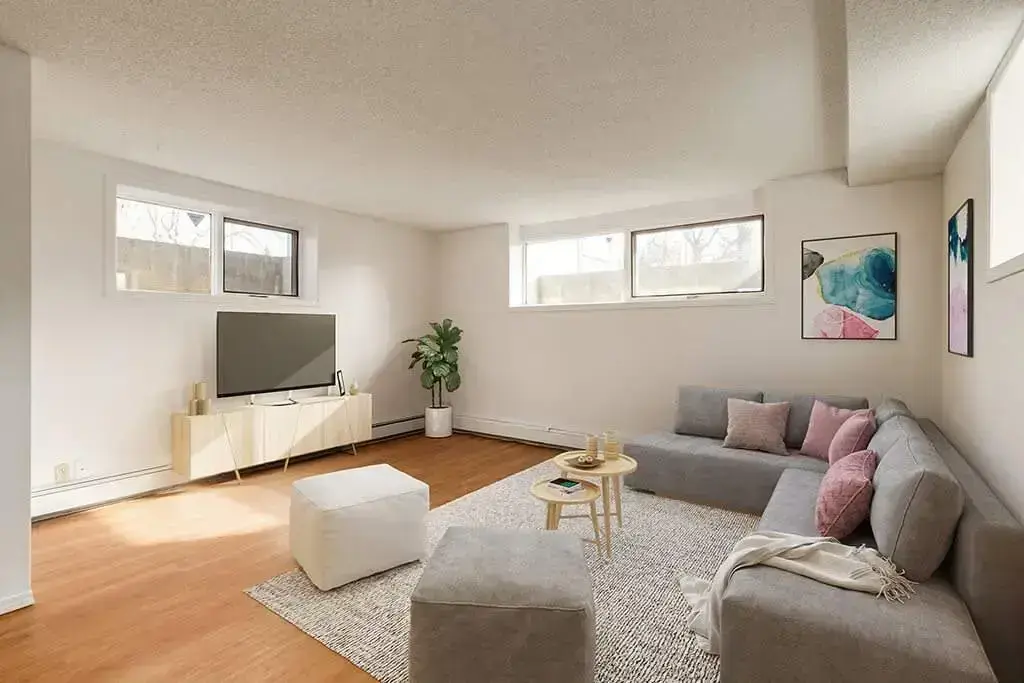 Bright living room with three windows at Bel-Aire Apartments in Lethbridge.