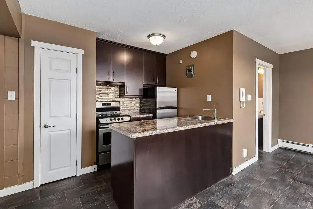 Modern Kitchen with stainless steel fridge and stove at 233 Bradbrooke Drive, Yorkton.