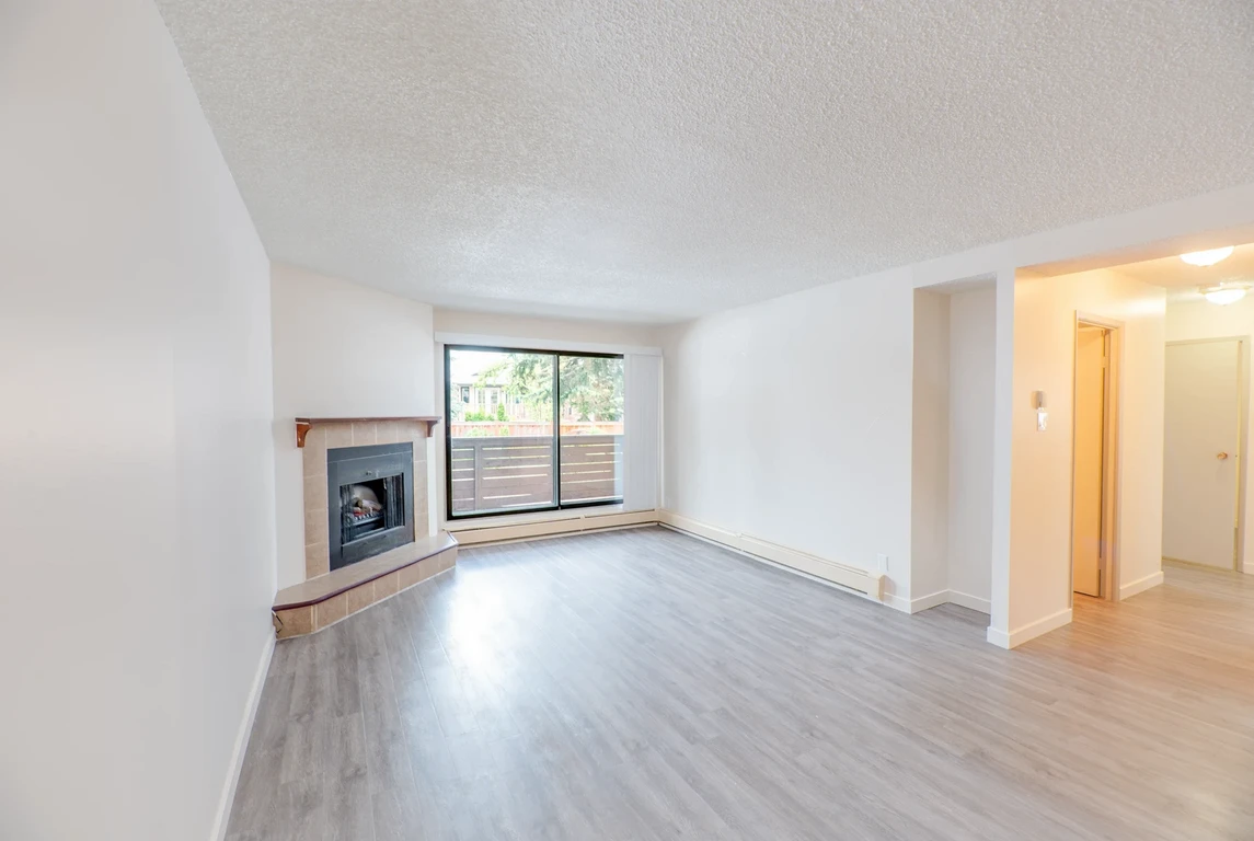 Living room with large windows and natural light at Glenmore Estates in Calgary.