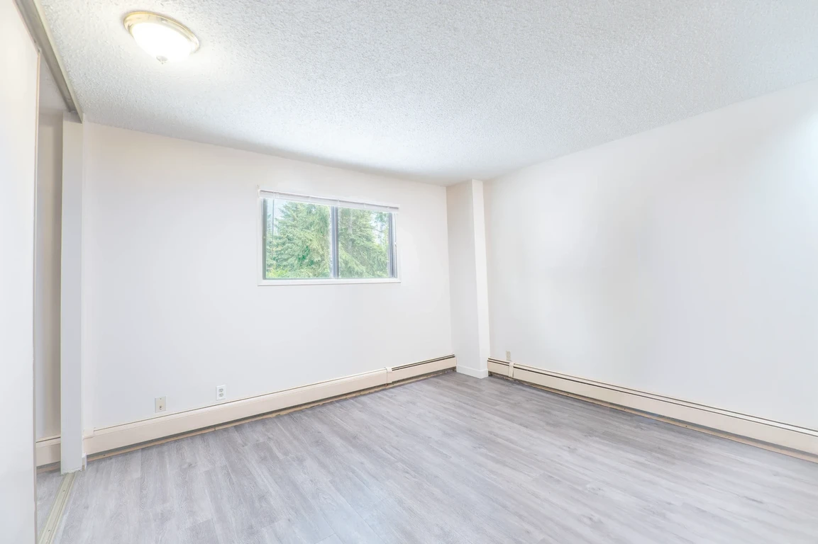 Comfortable size bedroom at Glenmore Estates in Calgary.