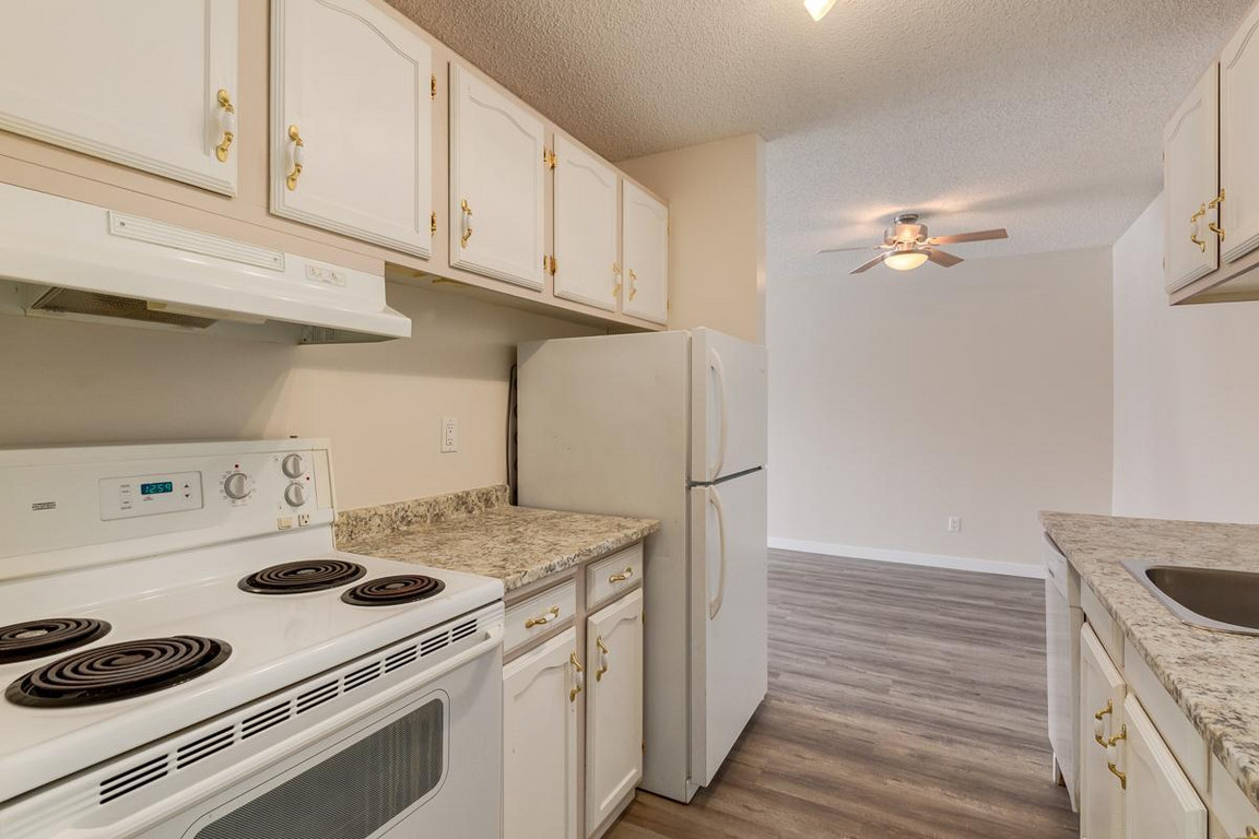 Galley style kitchen with appliances at  Hays Farm in Calgary. 