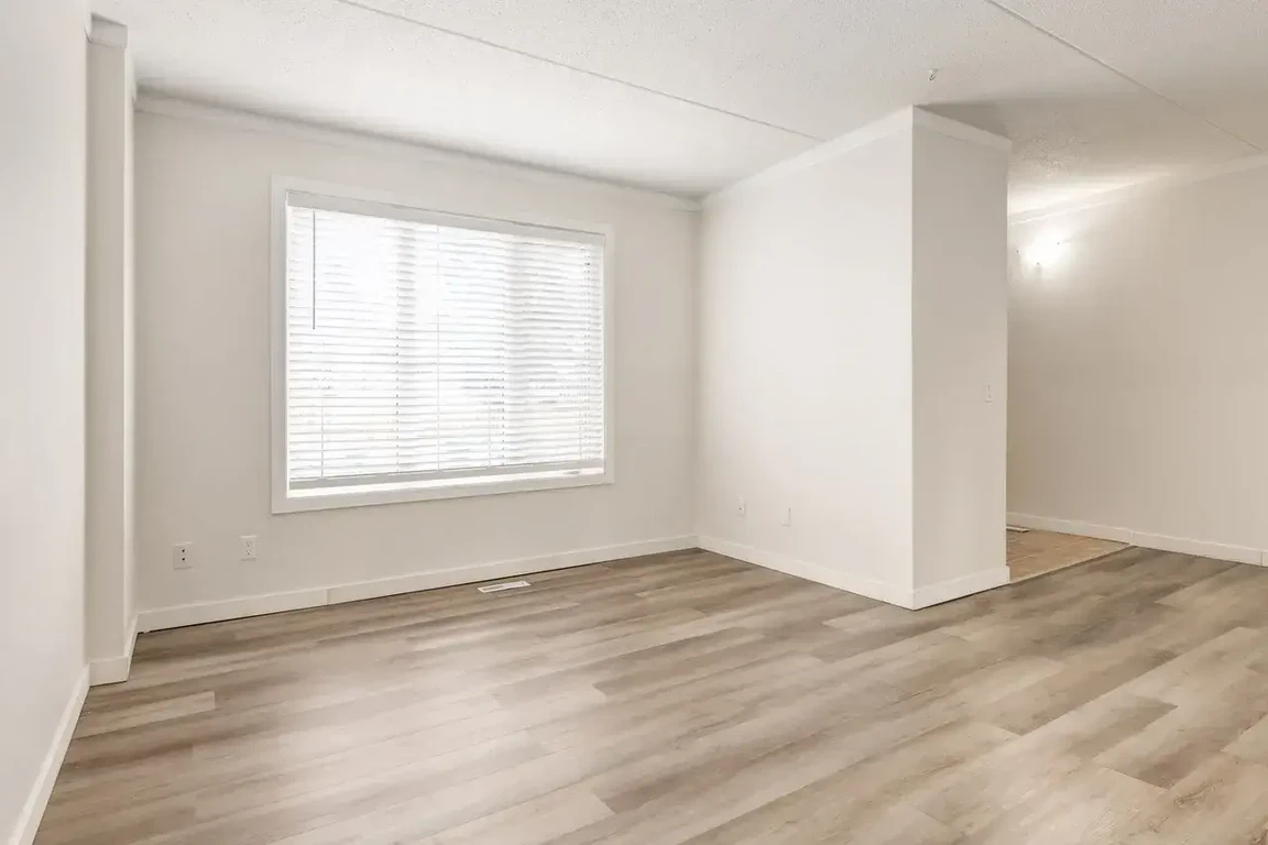 Living room with large windows and natural light at King's Alley in Calgary.