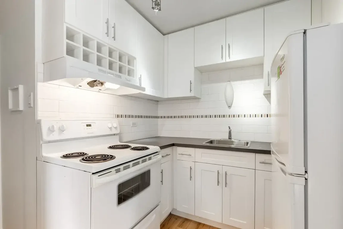 Updated kitchen featuring fridge and stove at Cameron Manor in Calgary.