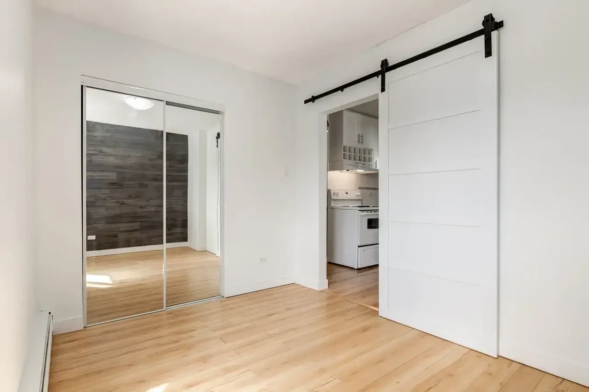Good size bedroom featuring barn door at Cameron Manor in Calgary.
