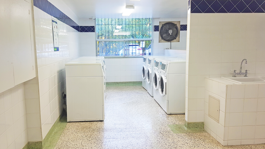 Bright white laundry room with blue tile stripe at the top and white dryers at Bathurst and Sheppard rental