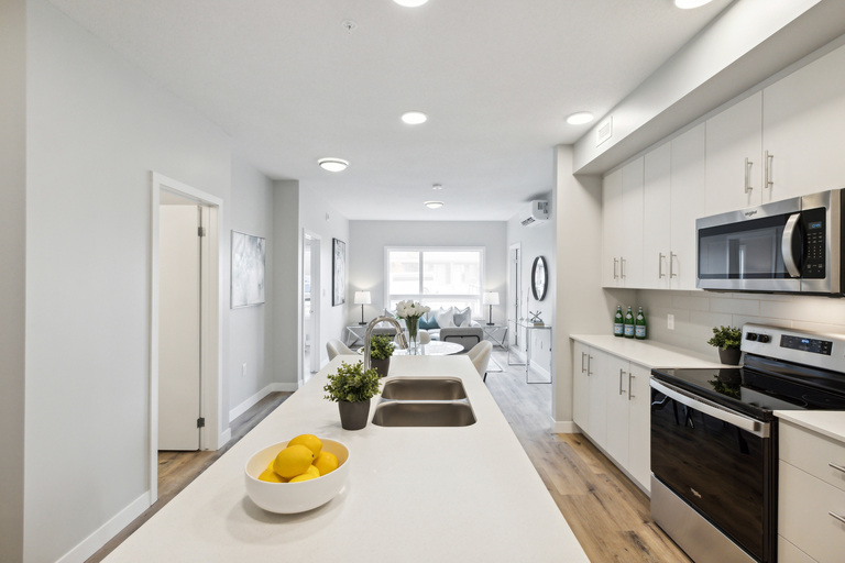 A modern kitchen with a bowl of lemons on the counter.