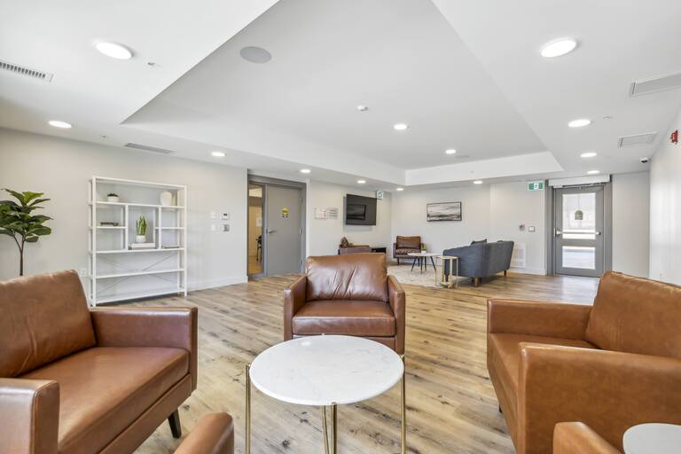 A living room with brown leather couches and a white coffee table.