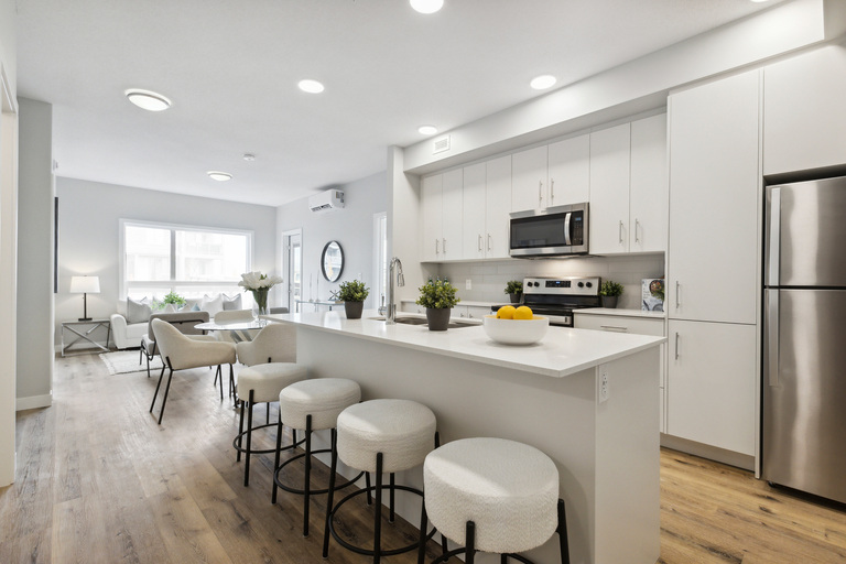 A modern kitchen with white cabinets and a large island.